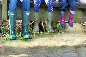 family wearing wellington boots sitting on a bridge