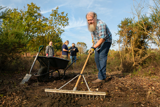 Conservation volunteer raking soil