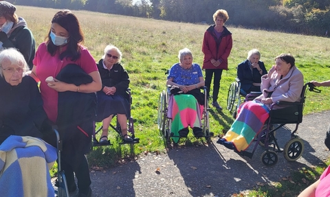 Elderly ladies in wheelchairs outdoors enjoying nature