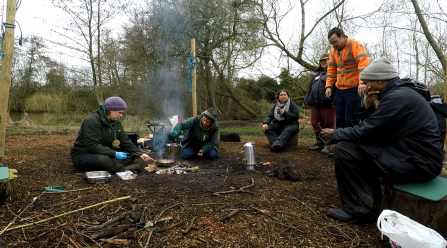 Engaging with Nature participants cooking around a fire