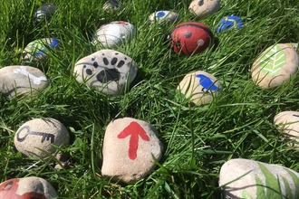 Story stones in grass by Charlotte Evetts