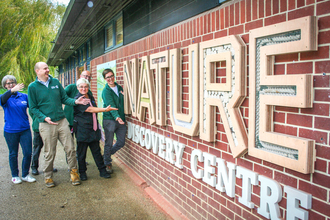 Nature Discovery Centre manager Steve Johnson with staff and volunteers showing off the new insect-friendly welcome sign