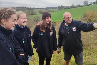 Man pointing something out to three girls