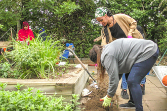 Members of the Slough Ujala Foundation community planting a garden at the Manor Park Pavilion
