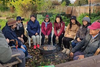 Members of the Hong Kong Community in Southcote, Reading enjoying a fireside chat outdoors