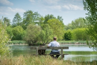 Man sitting on bench by Katharine Walley