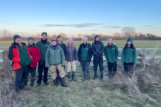 A group of Volunteer Trainees standing in a field in winter.