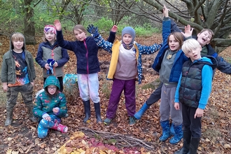 A group of young rangers standing around a picture made with leaves