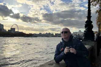 theearlybirder looking out across the Thames with binoculars in hand