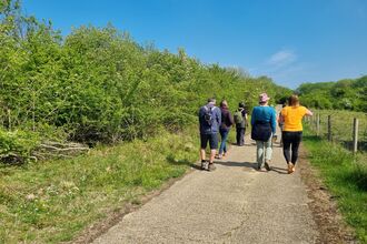 A group take a relaxed walk around site 