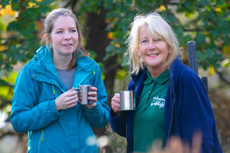 Two Wildlife Trust volunteers enjoying a tea break outdoors