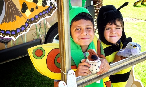 Children at wildlife photo frame dressed as bees and butterflies