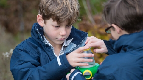 2 boys holding a bug viewer