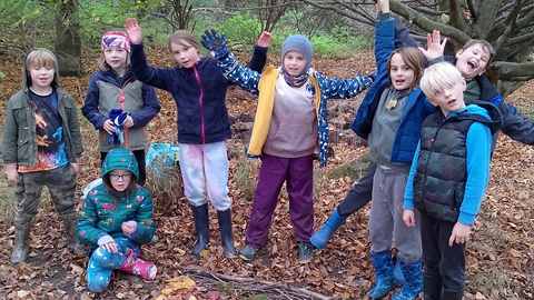 A group of young rangers standing around a picture made with leaves