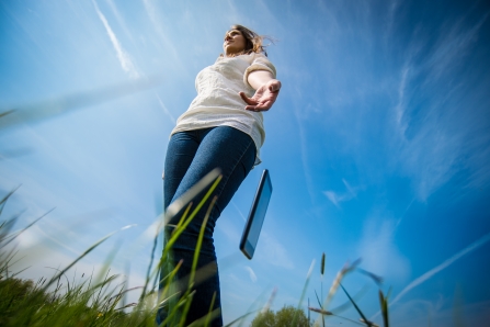 Woman throwing phone onto the grass