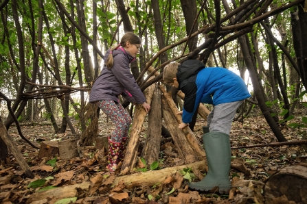 Girl and boy building a den