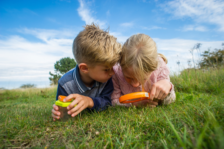 Children hunting for insects with a magnifier