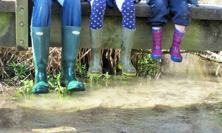 family wearing wellington boots sitting on a bridge