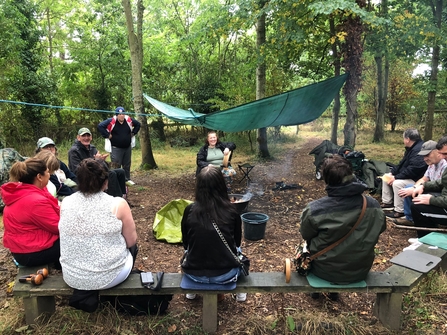 Engaging with Nature participants gather around a fire in the woods. Picture: Carrie Starbuck