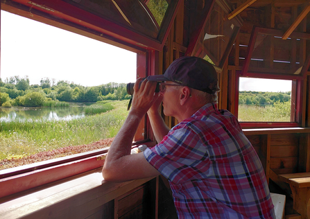 A man in a bird hide at College Lake by Lorraine Clarke - runner-up in the people category in the BBOWT Photography Competition 2022.