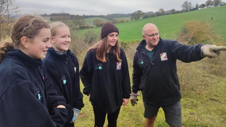 Man pointing something out to three girls