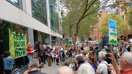 Crowd of people gathered around a speaker at the Restore Nature Now gathering