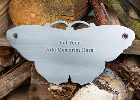 A metal plaque in the shape of a butterfly that can be engraved with a personal, commemorative message