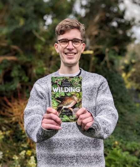 Person holding a copy of the book Wilding