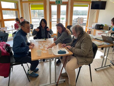 Group of people sitting around a table looking at pieces of paper
