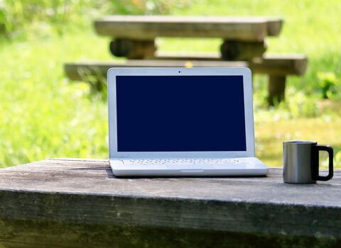 Laptop on outdoor bench
