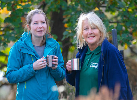 Two Wildlife Trust volunteers enjoying a tea break outdoors